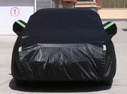Black waterproof car cover protecting a vehicle from outdoor elements.
