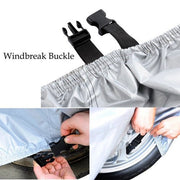Close-up of a windbreak buckle strap securing a silver car cover to a wheel