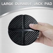 A person holding a large, durable black rubber jack pad with a ribbed grip surface.