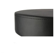 Close-up of a black faux leather circular ottoman stool