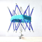Blue yarn wound around a metal knitting loom with blue support rods
