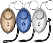 Set of three personal safety alarm keychains in gold, blue, and silver colors.