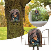 Whimsical garden gnome figurine sitting in a miniature window frame mounted on a tree trunk.