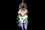 Dreamy white dreamcatcher with pastel pink, blue, and purple feathers and fairy lights.